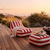 Red and White Striped Outdoor Bean Bag Lounger on a wooden deck during sunset.