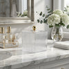 Clear Ribbed Acrylic Storage Box with Dust-Proof Lid on a marble countertop next to beauty products and flowers.