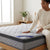 1.5M Double Comfort Mattress with a woman testing its comfort and texture in a bright bedroom setting.
