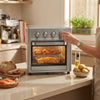 Silver 25L 3-in-1 Countertop Electric Oven & Air Fryer Unit in use, showcasing cooking fries and chicken.
