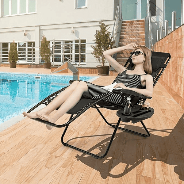 Woman relaxing on a Deluxe Folding Lounger Chair with Headrest and Side Tray by the pool.