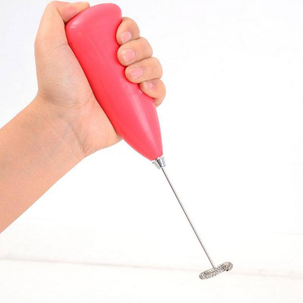 Hand holding a pink Coffee Milk Whisk Cappuccino Frother, perfect for creating frothy drinks at home.