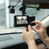 Person adjusting the 3-in-1 WDR Full HD 1080P Car DVR Dash Camera inside a vehicle.