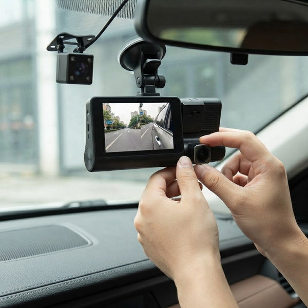 Person adjusting the 3-in-1 WDR Full HD 1080P Car DVR Dash Camera inside a vehicle.