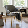 Sunpan Malachi Dining Armchair with modern design and padded seat, placed in a cozy living room setting.
