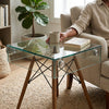 Shelf Bent Clear Glass Side Table Set featuring transparent top and wooden legs in a modern living room.