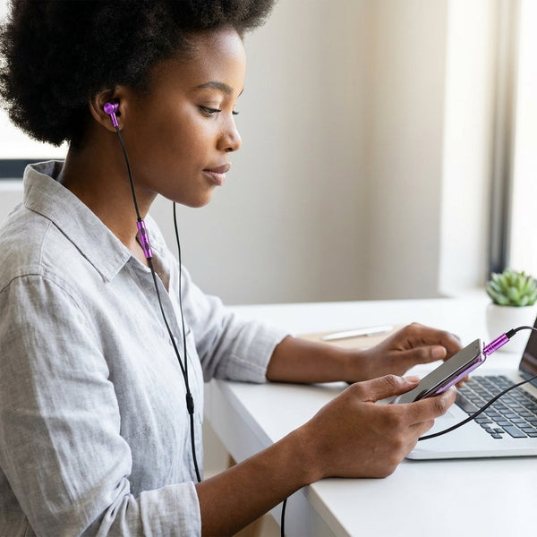 Woman using Compact True Wireless Bluetooth Earbuds while typing on a laptop, enjoying music and calls.