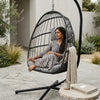 Steel Frame Hanging Egg Chair in a cozy outdoor setting with a woman relaxing in it.