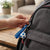 Person attaching a Football Silicone Keychain to a backpack, featuring a soccer ball charm and blue silicone strap.