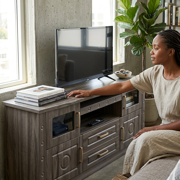A woman sitting next to a Sleek Living Room Entertainment TV Stand Console with a TV and books on display.