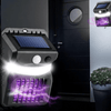 UV Mosquito Killer & Outdoor Lamp mounted near a door showcasing its solar panel and purple light for insect attraction.