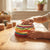 Child's hands interacting with a colorful 3D Motion Fidget & Sensory Toy on a wooden table.
