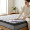 Woman testing the comfort of the 1.8M Double Comfort Mattress on a stylish bed frame.