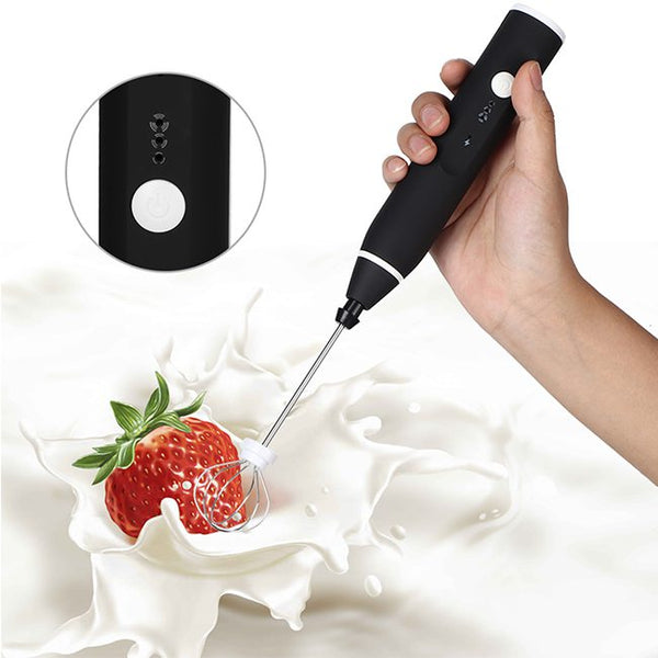 Handheld USB Milk Frother mixing milk with a splash and a strawberry, perfect for making frothy drinks.