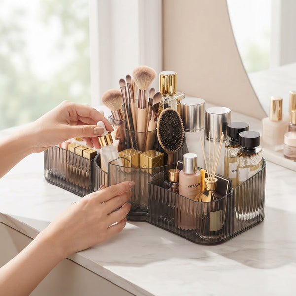 A hand organizing beauty products in a Multi-Compartment Cosmetic Desktop Storage Box on a marble dresser.