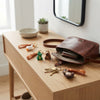 Hoppers PVC and Silicone 3D Animal Keychain displayed on a wooden table alongside a brown purse and small plants.