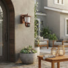 Solar Wall Light Security Camera Unit installed on a home exterior with plants and outdoor furniture visible.
