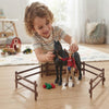 Child playing with Farm Horse & Rider Play Set, interacting with horse and rider figures in a farm-themed setting.