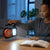 Person using a Rechargeable Camping Light with Solar Charger and Fan while reading a book in a cozy indoor setting.