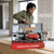 Industrial Brushless Electric Jack Hammer & Demolition Breaker in a toolkit, being examined by a person in a construction site.