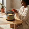 Multi-function BBQ Safety Switch Heater providing warmth as a woman enjoys a cozy indoor setting.