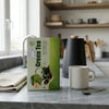 Pure Antioxidant Green Tea packaging on a kitchen counter with a kettle and mug, showcasing a healthy beverage choice.