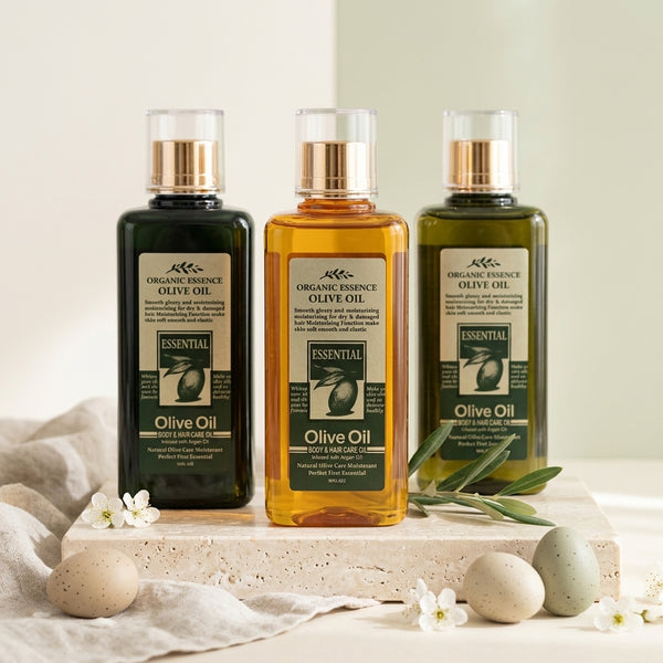 Olive Oil Infused with Argan Oil & Rose Petals bottles on a soft surface with flowers and stones.