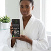 Woman holding Anti Hair Loss Shampoo Natural Plant Extract in a bathroom, promoting healthy hair regrowth.