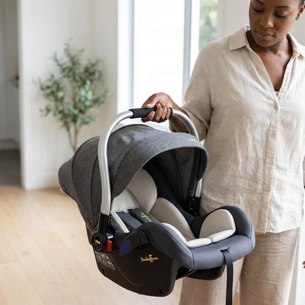 A woman holding the Baby Basket-Style Car Safety Seat, designed for newborn safety and comfort during travel.
