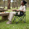 Woman sitting in a Lightweight Portable Metal Folding Chair at a picnic table in a forest.