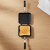Double-Sided Aluminum Toast Maker with grilled sandwich inside on wooden surface.