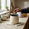 Remote Control Aromatherapy Fan resting on a kitchen countertop with a hand opening the lid.