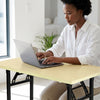 A woman using a laptop on a Single Computer Training Desk in a bright, organized workspace.