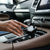 Hand adjusting the 100W Dual Socket & USB Car Charger in a modern vehicle console.