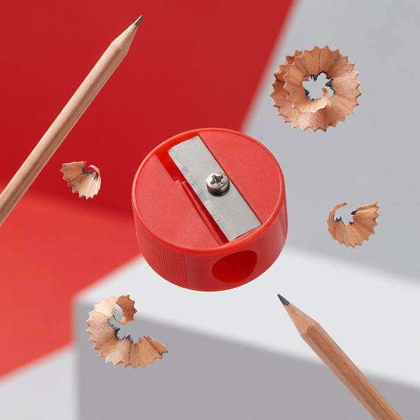 Single-Hole Bulk Plastic Standard Pencil Sharpener with shavings and pencils on a bright background.