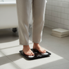Person standing on a Bluetooth Body Composition Scale in a bathroom setting.