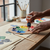 Person using 75ml Acrylic Paint - Burnt Sienna on a palette with various colors in an artistic workspace.