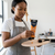 A woman using Acrylic Paint 75ml Raw Sienna on a palette, showcasing its smooth texture and vibrant color.