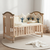 Wooden Baby Crib for Infants with Adjustable Mattress featuring soft bedding and decorative cushions.
