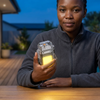 Mini Keychain LED Flashlight & Lighter held by a person in a cozy outdoor setting, demonstrating its compact design.