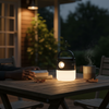 Solar Rechargeable LED Camping Light illuminating a table, ideal for outdoor reading and relaxing.