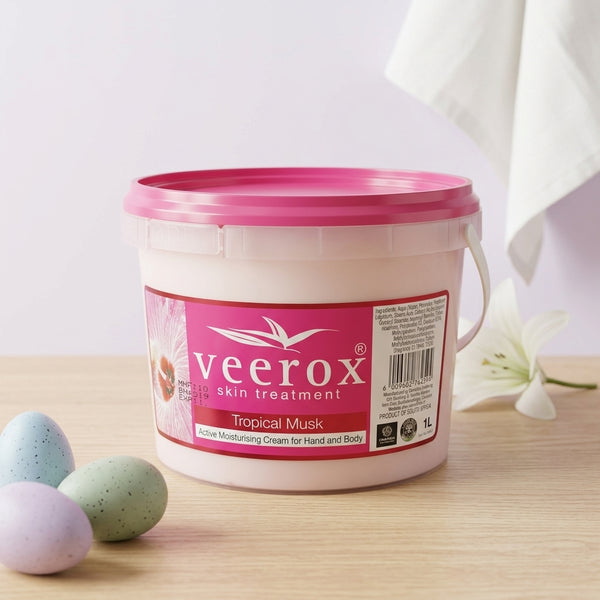 Tropical Musk Skin Treatment 1L in a white bucket on a wooden table with decorative eggs.