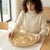 A woman holding a decorative 13-inch Eco-Friendly Charger Plate while setting the table.