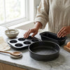 3 Piece Non Stick Bakeware Set displayed on a kitchen countertop, showcasing a muffin pan, loaf pan, and round cake pan.