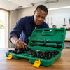 Man using the Heavy Duty 26-Piece Socket Wrench Set in a workshop with a green carrying case.