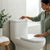 Modern Ceramic One-Piece Toilet Unit in a stylish bathroom with a woman using it.