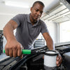 Reinforced Handcuff-Style Oil Filter Wrench Tool in use by a mechanic removing an oil filter.