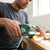 Person using a 42mm PVC Pipe Cutter Tool on white piping during plumbing work.