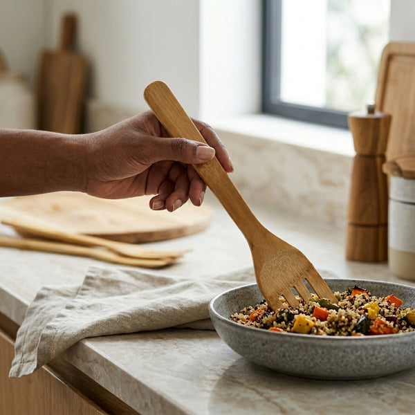 Natural House Premium Olive Wood Kitchen Utensil stirring a vibrant salad in a rustic kitchen setting.