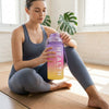 Woman holding a 4-in-1 Motivational Gradient Water Bottle Set during yoga workout.